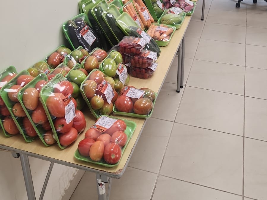 Legumes orgânicos organizados na mesa da feira da Lattuga